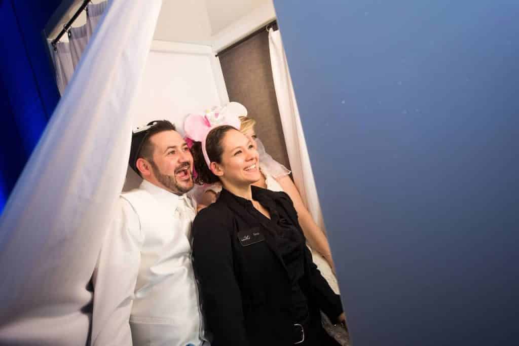 photo booth attendant in photo booth with bride and groom