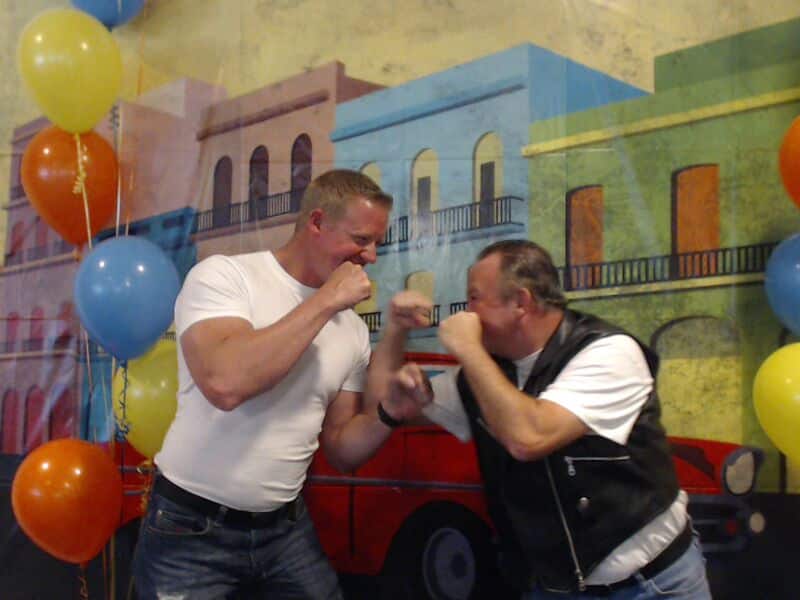 two men posing as if to fight in a photo booth