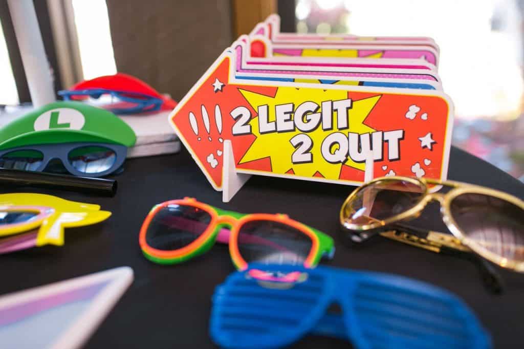 2 legit 2 quit sign on table with 90s-themed photo booth props