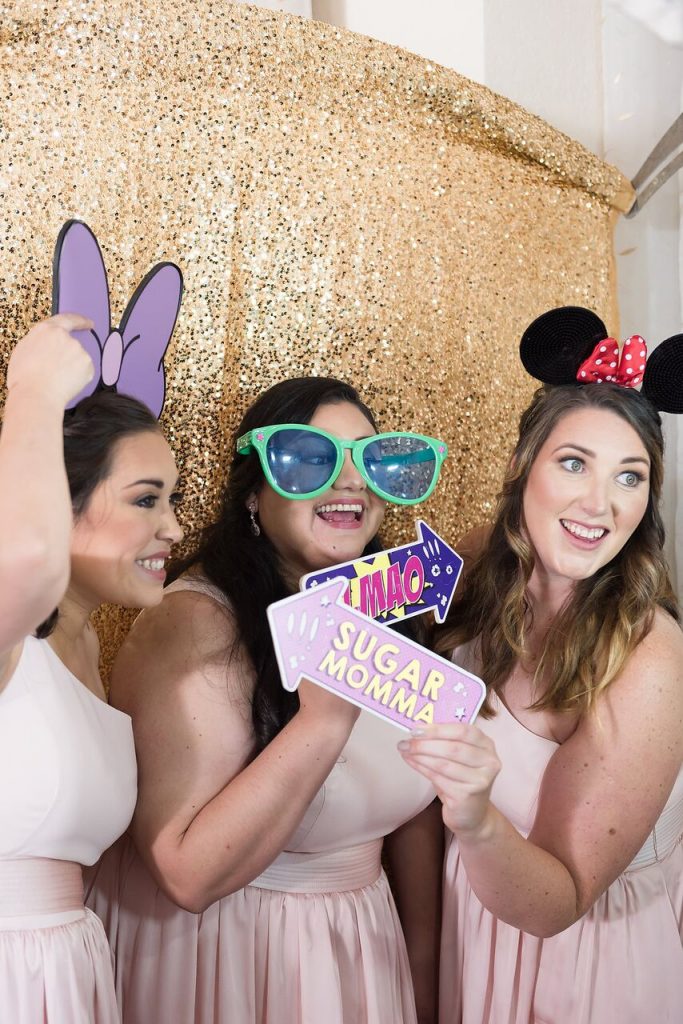 bridesmaids posing with Disney photo booth props