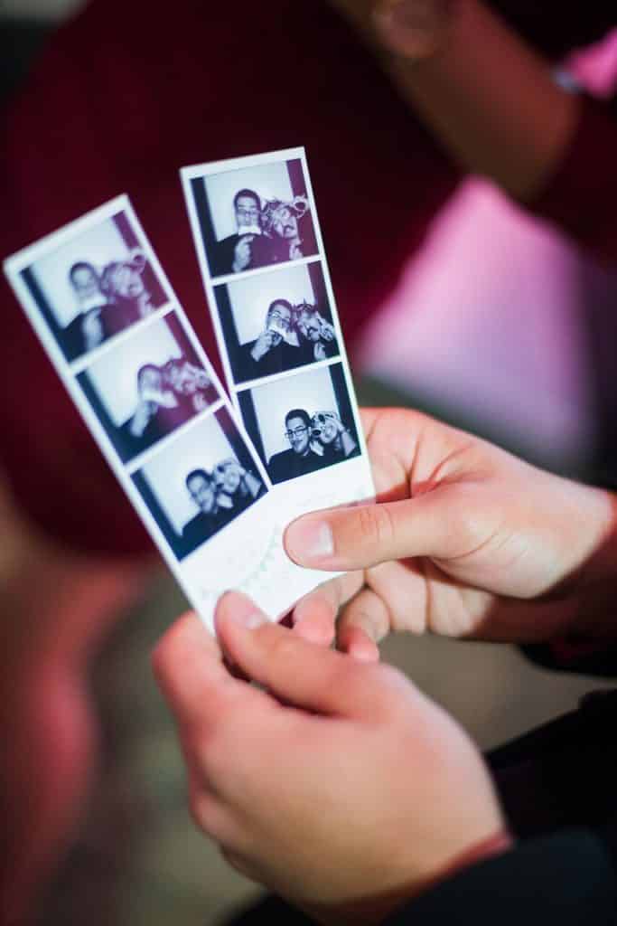 hands holding photo booth strips