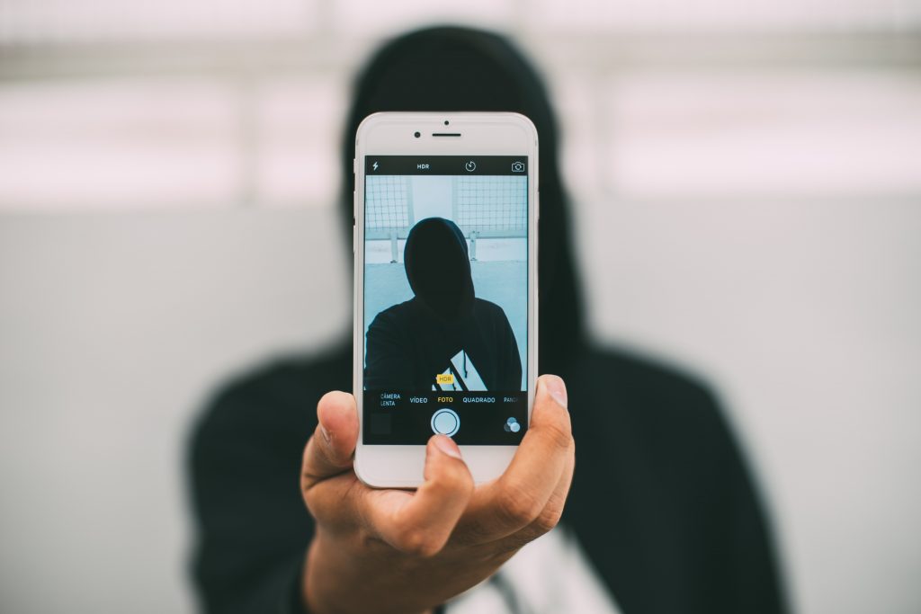 man taking a selfie with phone turned around