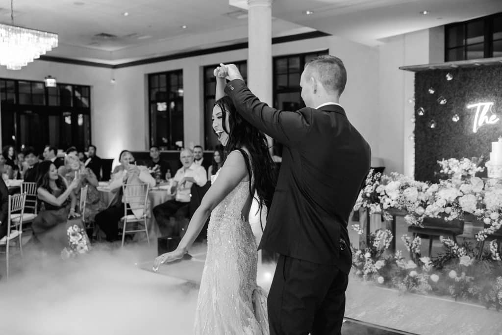 b&w photo of Adam spinning his bride carlyn on the dance floor at their wedding