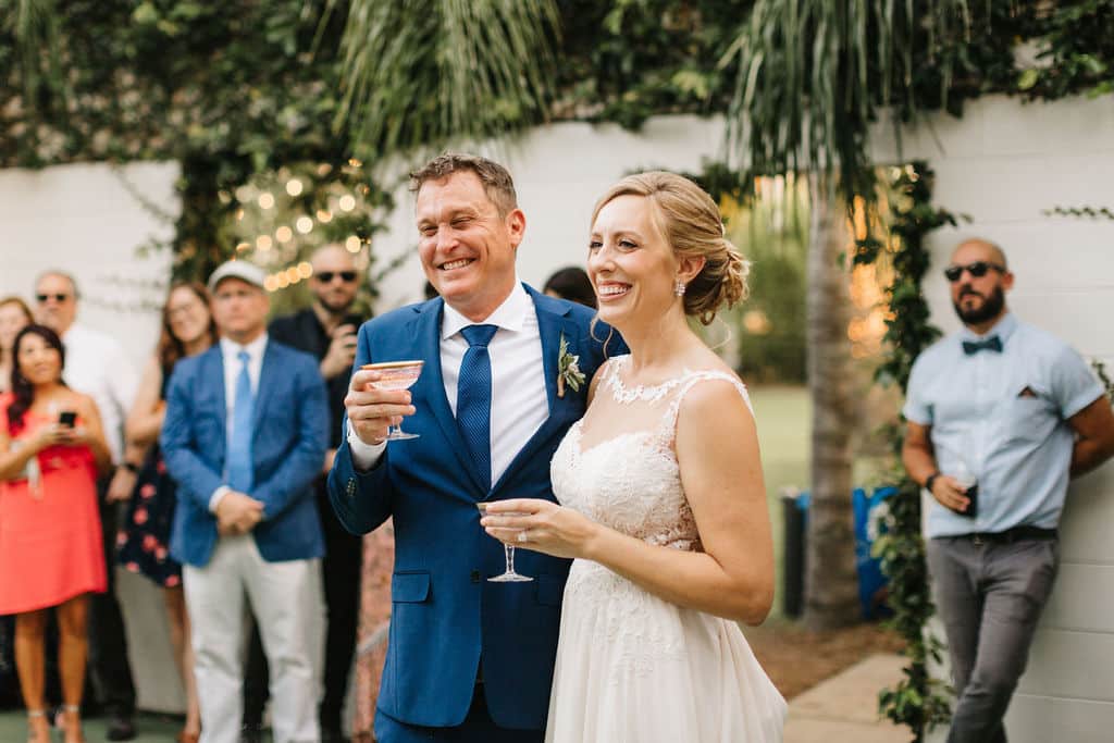 bride and groom hearing toast in garden setting