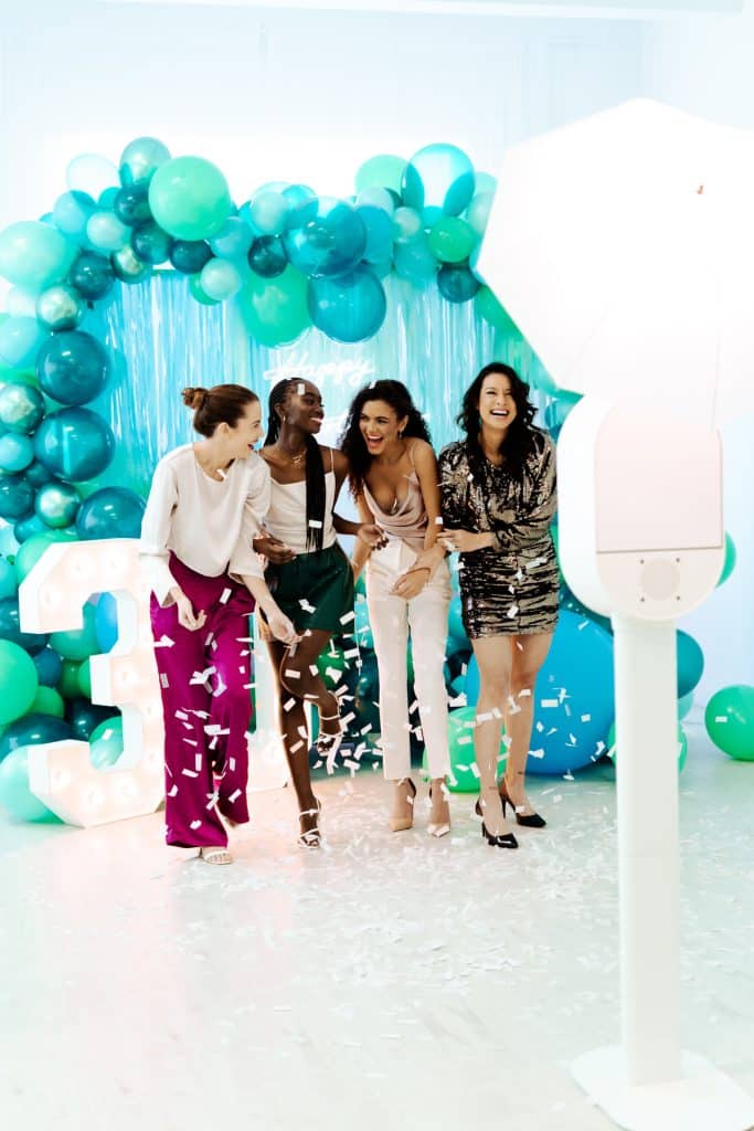 confetti in a photo booth with a custom balloon backdrop