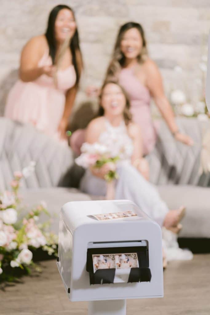 ladies posing in white open air photo booth