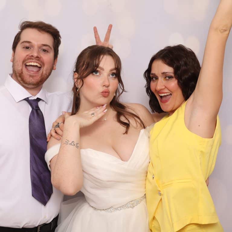 Bride and wedding guests posing together in the photo booth