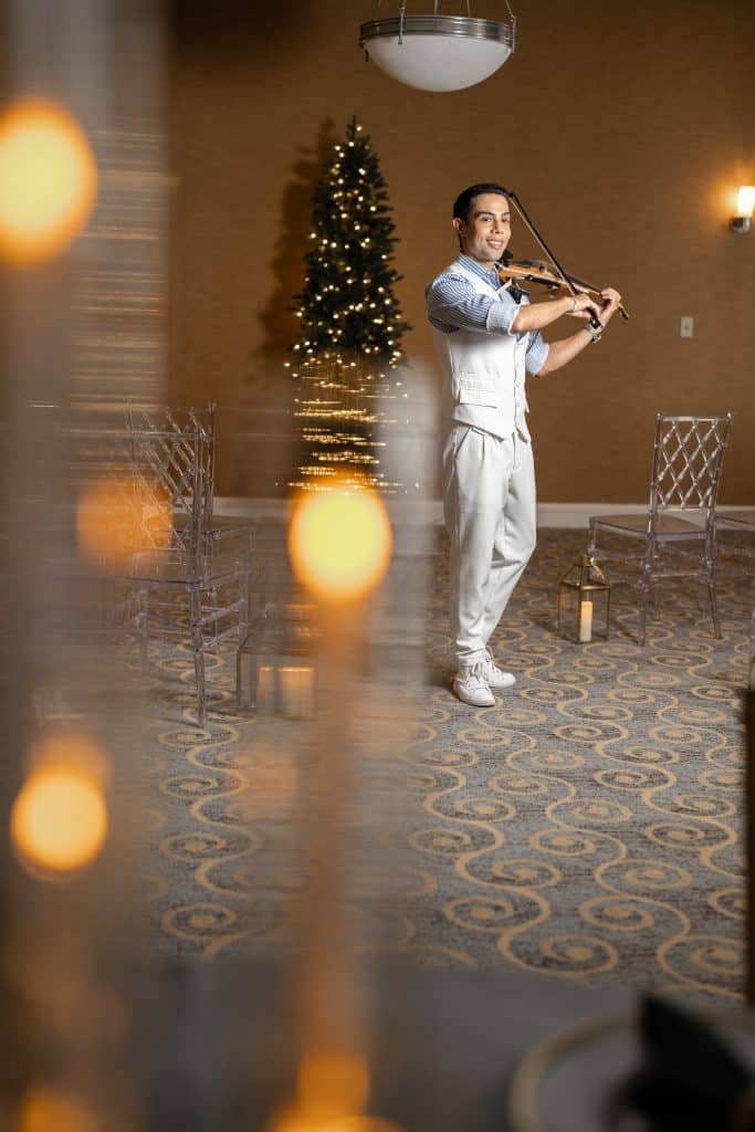 Violinist performing by candlelight at a DoubleTree Orlando Downtown holiday party