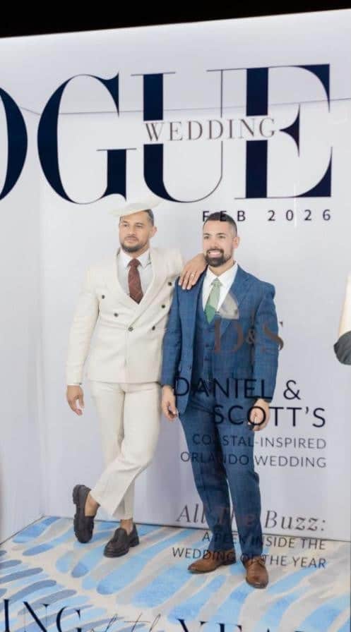 Two wedding guests posing in a Photo Booth Rocks Vogue-style magazine booth at the Conrad Orlando